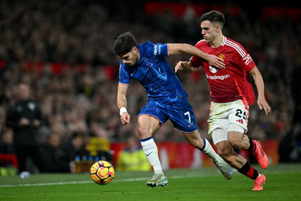 Chelsea’s Portuguese midfielder #07 Pedro Neto vies for the ball with Manchester United’s Uruguayan midfielder #25 Manuel Ugarte during the English Premier League football match between Manchester United and Chelsea at Old Trafford in Manchester, north west England, on November 3, 2024. (Photo by Paul ELLIS / AFP) 