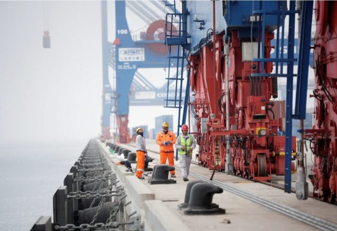 Workers stand next to cranes at the new megaport being built by China's state-owned Cosco Shipping, promising to shorten sea routes to Asia for Peruvian and some Brazilian goods, in Chancay, Peru October 24, 2024. REUTERS/Angela Ponce/File Photo