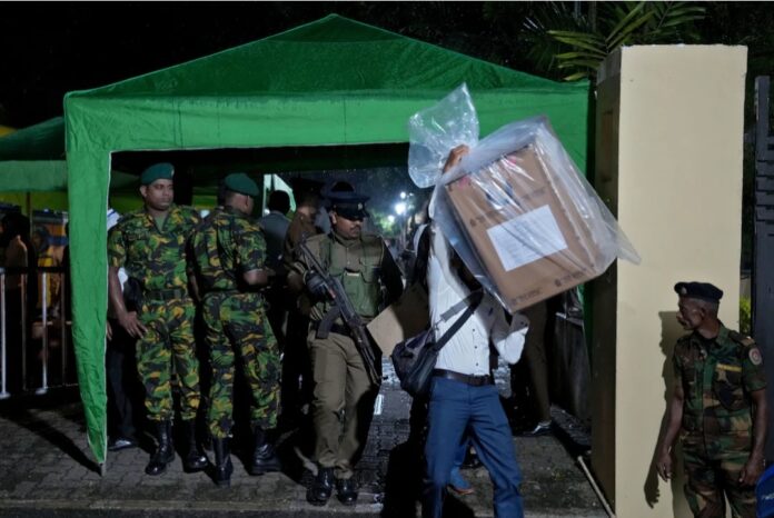 An election official carries a ballot box next to security force personnel at a vote counting centre after the voting ended for the parliamentary election in Colombo, Sri Lanka, November 14, 2024. REUTERS/Thilina Kaluthotage