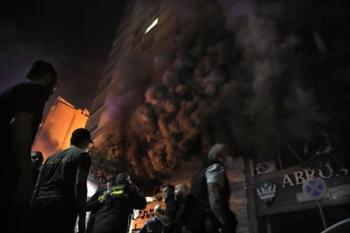 Firefighters and rescuers gather outside a computer shop hit in an Israeli airstrike in central Beirut, Sunday, Nov. 17, 2024. (AP Photo/Bilal Hussein)