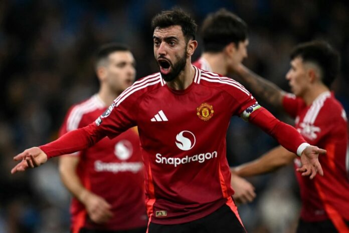 Manchester United’s Portuguese midfielder #08 Bruno Fernandes encourages fans during the English Premier League football match between Manchester City and Manchester United at the Etihad Stadium in Manchester, north west England, on December 15, 2024. (Photo by Paul ELLIS / AFP)