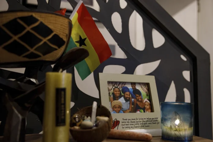 A family photo of Keachia Bowers, Damon Smith, and their children sits in their home in Accra, Ghana, Friday, Dec. 6, 2024. The family relocated to Ghana from Florida and has obtained Ghanaian citizenship. (AP Photo/Misper Apawu)