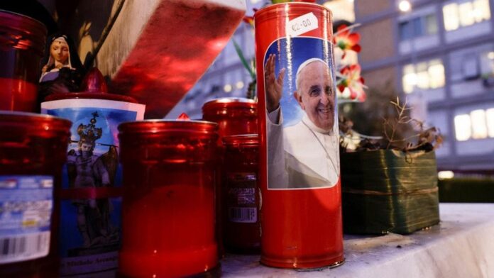 A view of a candle with an image of Pope Francis, on the day he was admitted to the Gemelli Hospital to continue treatment for ongoing bronchitis in Rome, Italy, February 14, 2025. REUTERS/Remo CasilliRemo Casilli/Reuters
