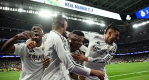 Real Madrid players celebrate their second goal scored by Real Madrid’s French forward #09 Kylian Mbappe during the UEFA Champions League knockout phase play-off football match between Real Madrid CF and Manchester City at the Santiago Bernabeu stadium in Madrid on February 19, 2025. (Photo by JAVIER SORIANO / AFP)