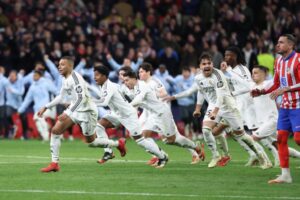 Real Madrid players celebrate their victory after the UEFA Champions League Round of 16 second leg football match between Club Atletico de Madrid and Real Madrid CF at the Metropolitano stadium in Madrid on March 12, 2025. (Photo by Thomas COEX / AFP)