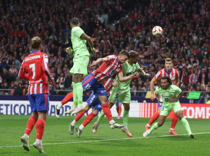 Atletico Madrid’s French defender #15 Clement Lenglet and Barcelona’s Spanish defender #05 Inigo Martinez Berridi vie for a header during the Spanish Copa del Rey (King’s Cup) semi-final second leg football match between Club Atletico de Madrid and FC Barcelona at Metropolitano Stadium in Madrid on April 2, 2025. (Photo by Pierre-Philippe MARCOU / AFP)