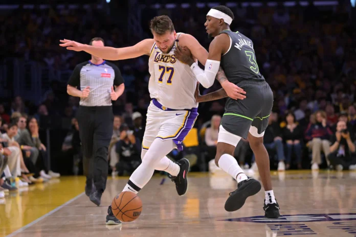  April19, 2025; Los Angeles, California, USA; Los Angeles Lakers guard Luka Doncic (77) is fouled by Minnesota Timberwolves forward Jaden McDaniels (3) in the first quarter at Crypto.com Arena. Mandatory Credit: Jayne Kamin-Oncea-Imagn Images
