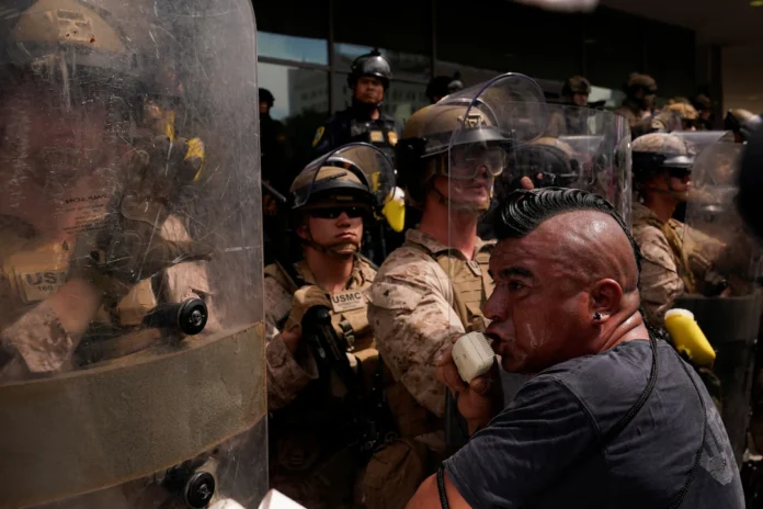 U.S. Marines stand guard as people protest against U.S. President Donald Trump's policies and federal immigration sweeps during a No Kings Day demonstration in Los Angeles, California, U.S., June 14, 2025. REUTERS/David Ryder