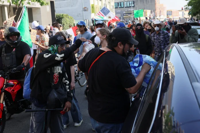 Demonstrators receive water handed out from a vehicle during a protest against federal immigration sweeps in downtown Los Angeles, California, U.S. June 10, 2025. REUTERS/Leah Millis