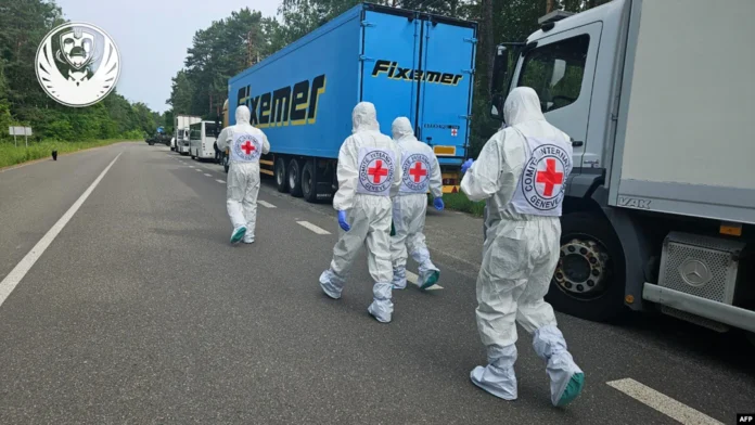 International Red Cross representatives walk past a convoy of refrigerator trucks carrying the bodies of Ukrainian soldiers being repatriated on June 11.