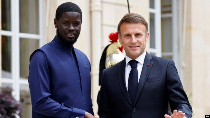 FILE - Senegal's President Bassirou Diomaye Faye (L) shakes hands with France's President Emmanuel Macron as they meet at the Elysee Presidential Palace in Paris, June 20, 2024.