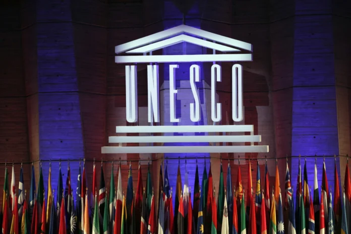 FILE - The logo of the United Nations Educational, Scientific and Cultural Organisation (UNESCO) is seen during the 39th session of the General Conference at the UNESCO headquarters in Paris, Nov. 4, 2017. The United States has formally rejoined the U.N.'s scientific, educational and cultural organization. Washington’s return to the Paris-based UNESCO was based mainly on concerns that China has filled a leadership gap in the organization since the U.S. withdrew during the Trump administration. (AP Photo/Christophe Ena, File)