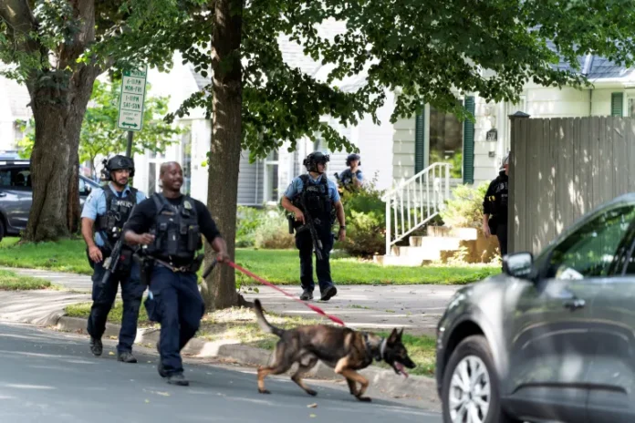 Law enforcement uses a dog to search a neighbourhood near Annunciation Church in Minneapolis after the shooting on August 27, 2025 [Tim Evans/Reuters]
