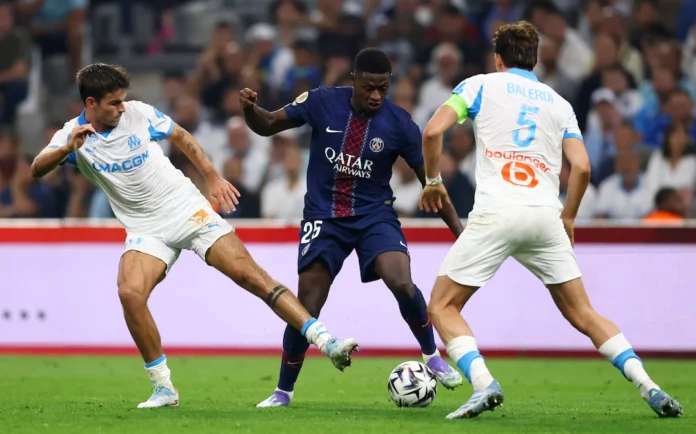 Soccer Football - Ligue 1 - Olympique de Marseille v Paris St Germain - Orange Velodrome, Marseille, France - September 22, 2025 Paris St Germain's Nuno Mendes in action with Olympique de Marseille's Leonardo Balerdi and Matt O'Riley REUTERS/Manon