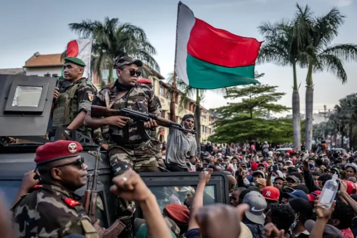 Members of the Madagascar CAPSAT army contingent gather with protesters as the demonstrators celebrate their arrival Antananarivo's City Hall on October 11, 2025 [Luis Tato/AFP]