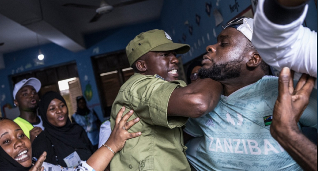 Tanzania A Tanzanian police officer stops a man accused by electoral officials of attempting to taint the voting process at a polling station in Stone Town on October 29, 2025, during Tanzania’s presidential elections. Photo by MARCO LONGARI / AFP