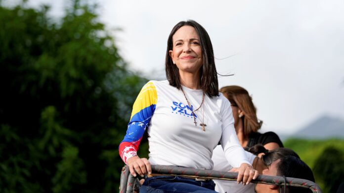 Opposition leader Maria Corina Machado rides atop a truck during a closing election campaign rally for presidential candidate Edmundo Gonzalez in Caracas, Venezuela, July 25, 2024 (AP photo by Matias Delacroix).