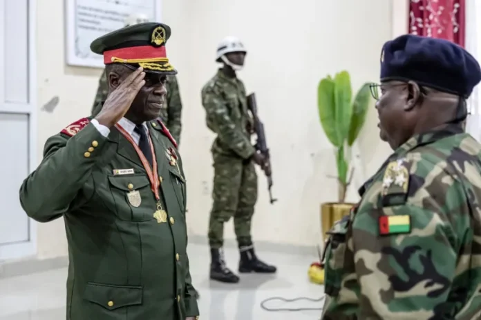 Guinea Bissau Army General Horta Nta Na Man (left) salutes an officer during the swearing-in ceremony as the transitional leader and chief of the High Command in Bissau on Thursday, November 27, 2025 [Patrick Meinhardt/AFP]