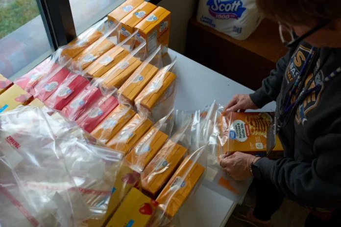 Jen Janecek Hartman helps prepare bagged meals for a food bank for students at Nueta Hidatsa Sahnish College on Oct. 30 in New Town, N.D. John Locher/AP