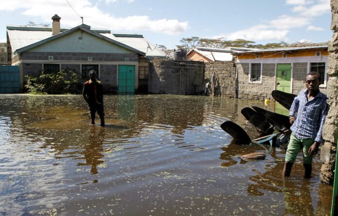 Residents wade through flood waters near their submerged houses after the water levels at Lake Naivasha bulged to record high, pushing hundreds of people from surrounding farms around Naivasha town within Nakuru county, Kenya November 8, 2020. Picture taken November 8, 2020. REUTERS/Monicah Mwangi