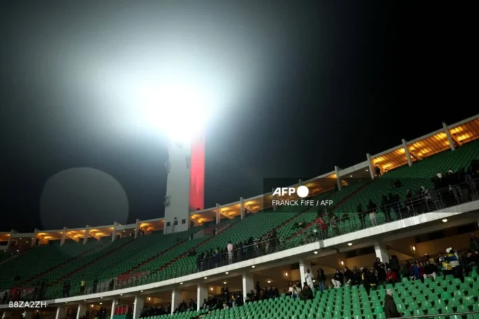 Supporters begin to arrive in the rain ahead of the Africa Cup of Nations (CAN) Group F football match between Cameroon and Gabon at Adrar Stadium in Agadir on December 24, 2025. (Photo by Franck FIFE / AFP)
