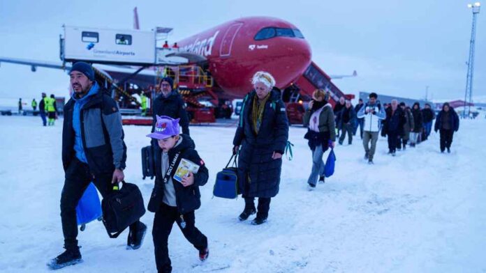 People walk out from a plane after arriving at the airport, in Nuuk, Greenland, on Monday, Jan. 12, 2026. (AP Photo/Evgeniy Maloletka)