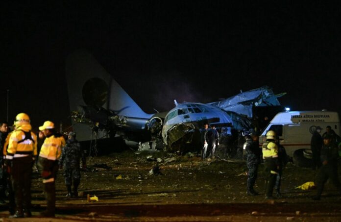 Members of the armed forces stand guard next to the wreckage of a military plane that crashed in el Alto, near La Paz on February 27, 2026. (Photo by AIZAR RALDES / AFP)
