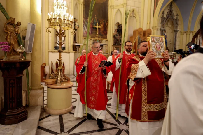 Christian worshippers mark Palm Sunday, following the cancellation of the traditional Palm Sunday procession from the Mount of Olives, amid restrictions on gathering in large groups and the U.S.-Israel conflict with Iran, at the Latin Patriarchate of Jerusalem in Jerusalem's Old City March 29, 2026. REUTERS/Ammar Awad 
