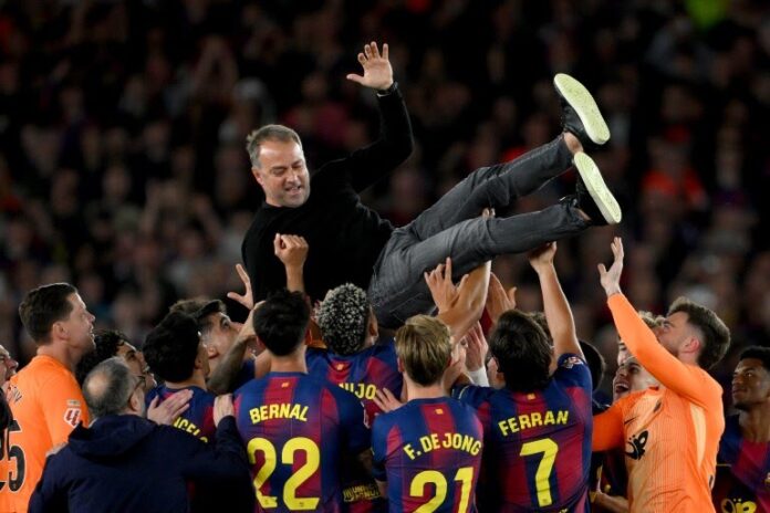 Barcelona coach Hansi Flick is thrown in the air by his players as they celebrate winning the La Liga title [David Ramos/Getty Images]